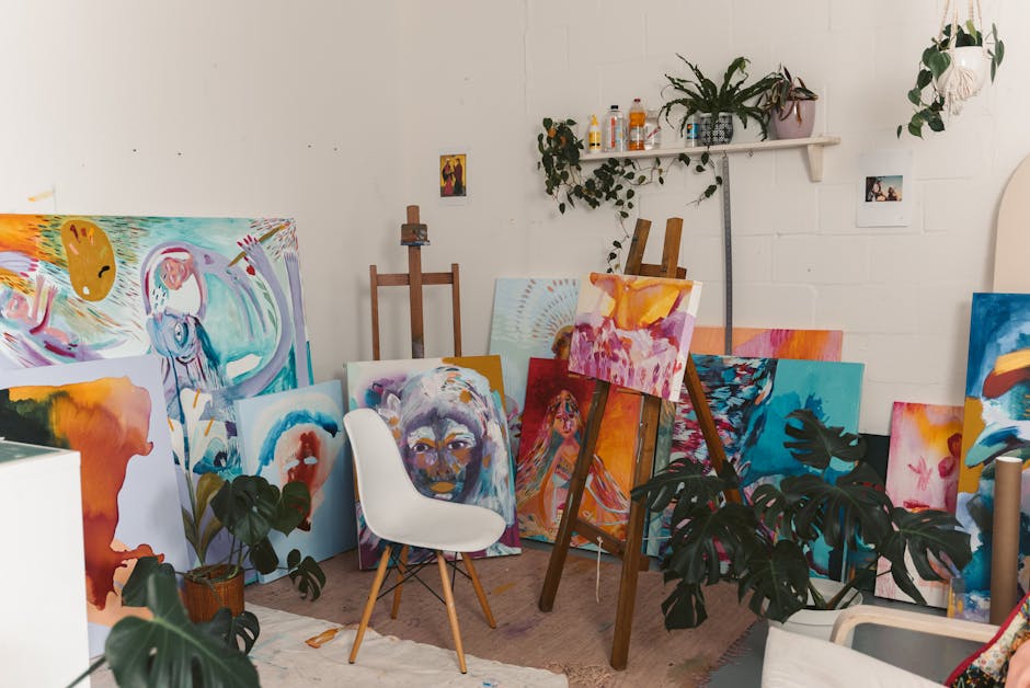 A vibrant art studio filled with colorful abstract paintings, easels, and indoor plants.