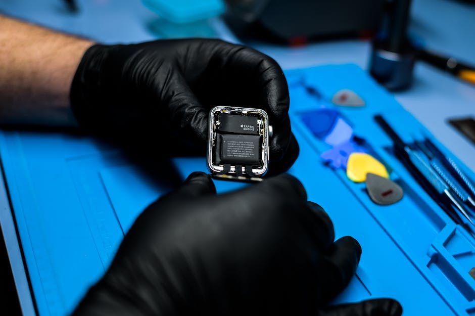 Technician disassembling smartwatch with precision tools in a repair workshop.